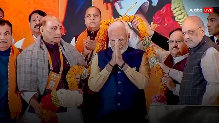 To whom did Amit Shah gesture while garlanding PM Modi, caught on camera